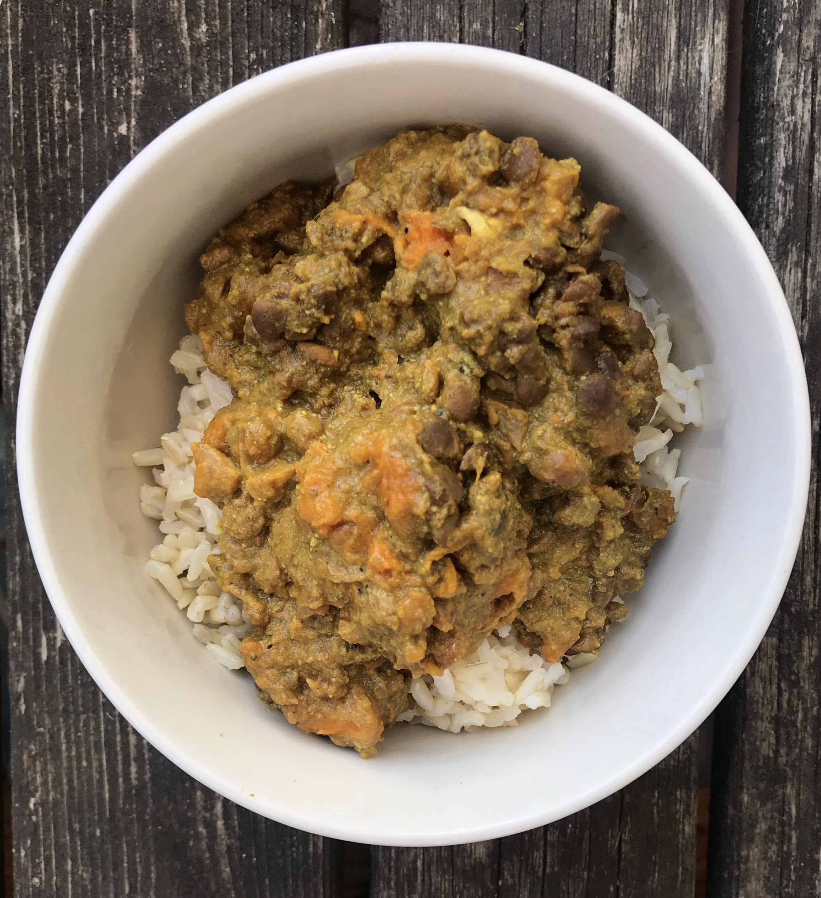 Yellow sweet potato curry over a bed of rice in a bowl