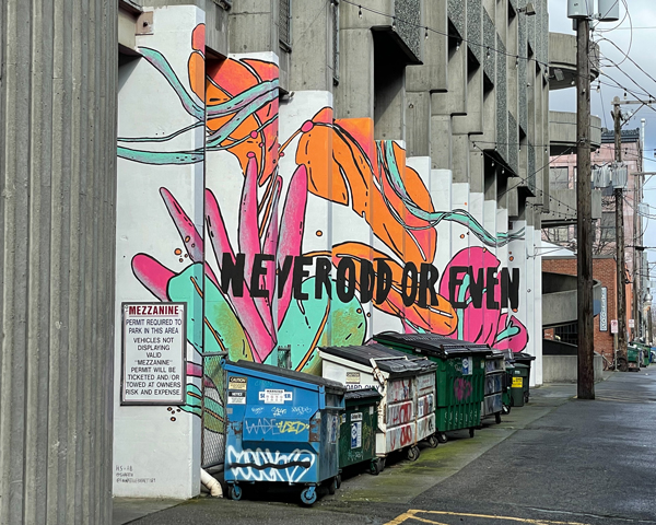 This staggered mural that says "Never Odd or Even" spans many concrete pillars.