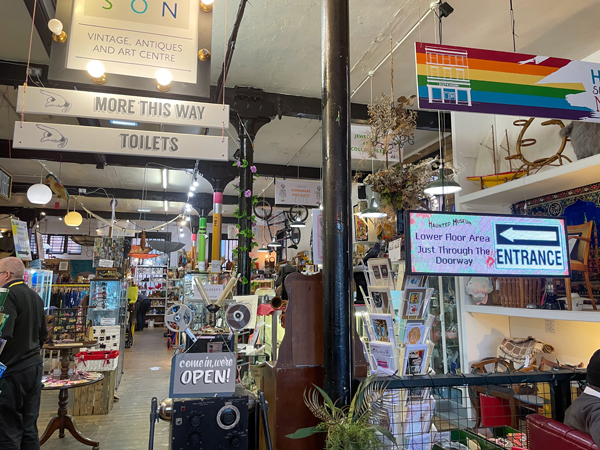 Signs inside the Hopkinson Vintage shop point where things are,while cards, trinkets, and decorative objects display throughout the first floor of the store.