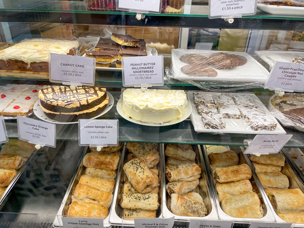An assortment of cakes and savory pastries are in a display case at V-Spot.