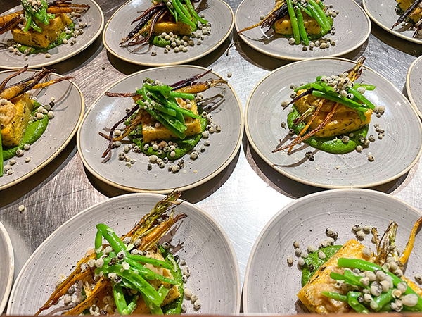 Rows of third course plates are ready to serve to diners.