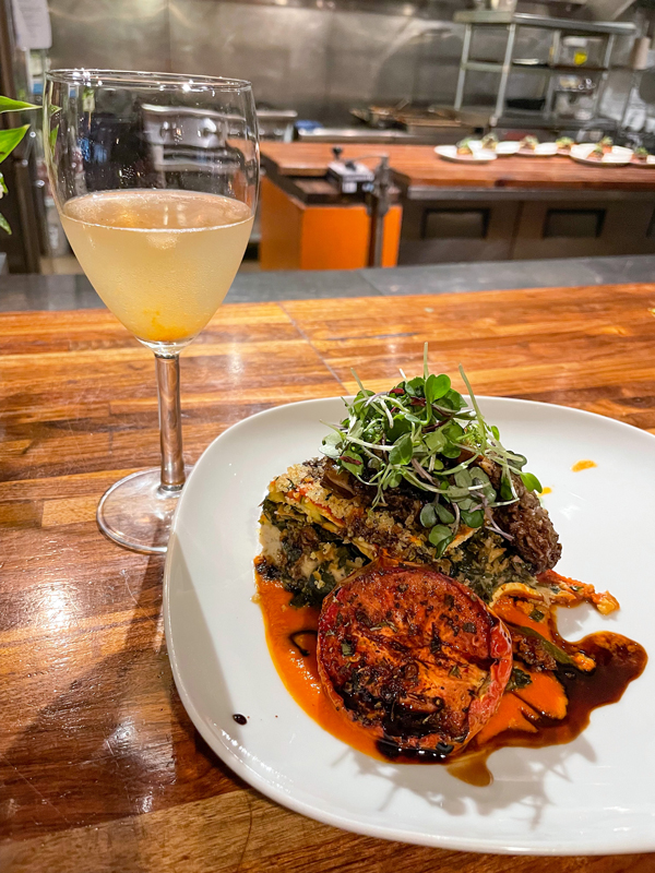 Layered squash gratin comes with a roasted tomato, morel mushrooms, and microgreens, and is served with a basil lemonade.